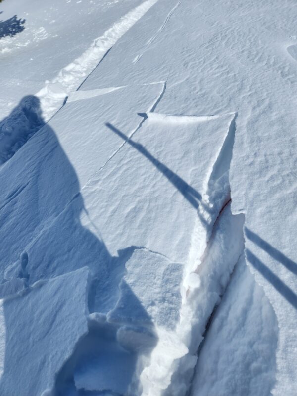 Shooting cracks above anothe ski track in wind-deposited snow