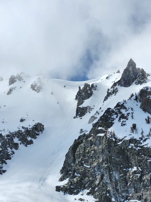 Clouds, big cornices intact, and old wet loose on the Mammoth Crest